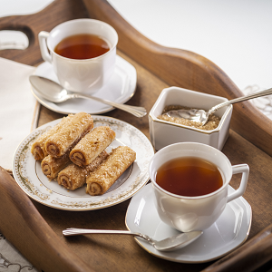 fennome pastries on a plate with hot tea and sugar